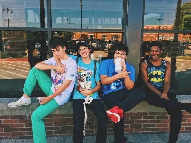 Teens in recovery sitting outside a store having fun.