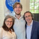 John and his parents hugging.