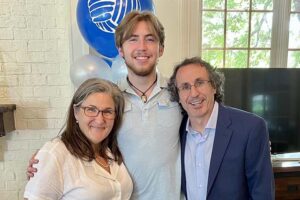 John and his parents hugging.